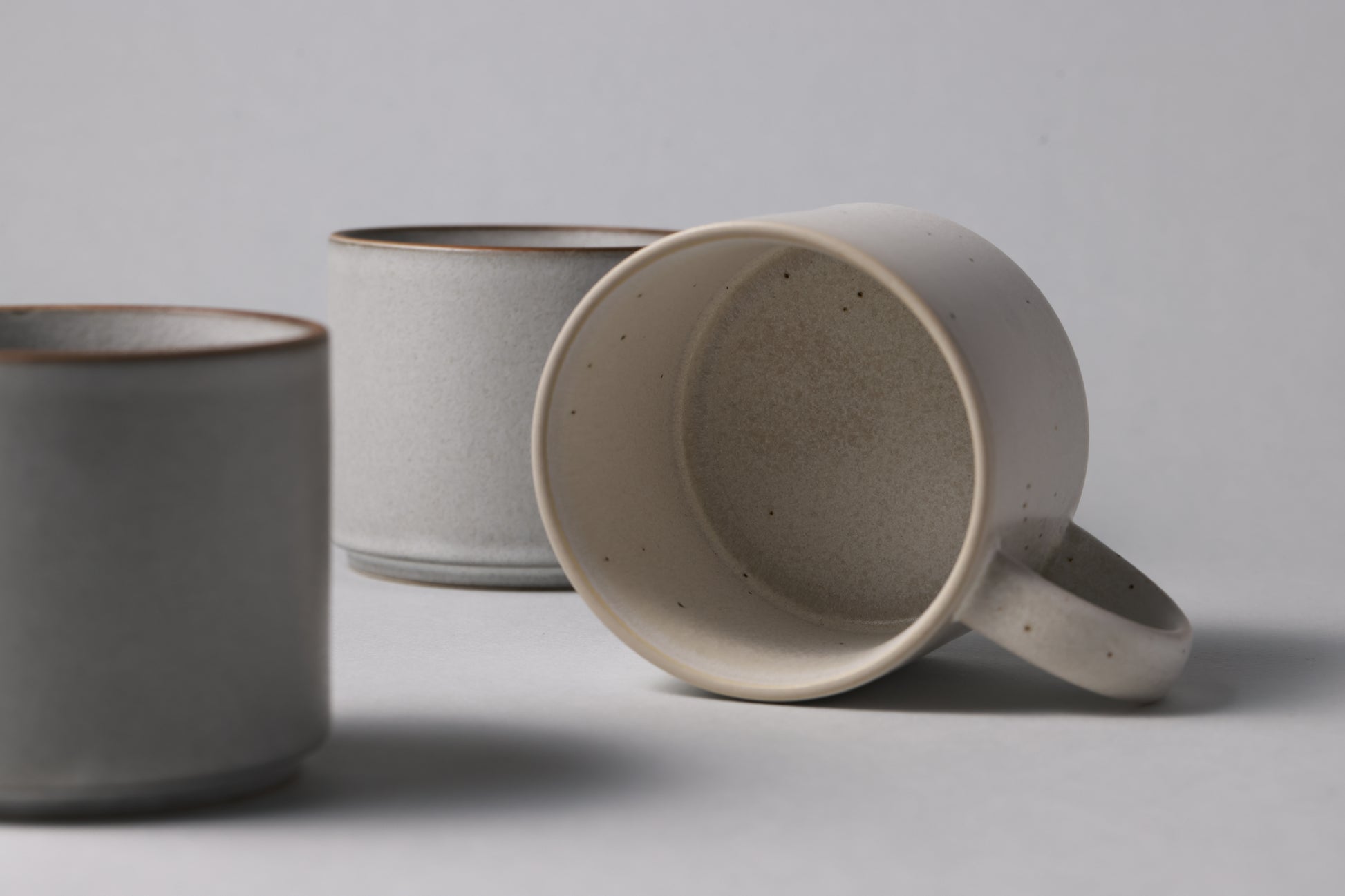 Three stoneware mugs in soft gray and beige