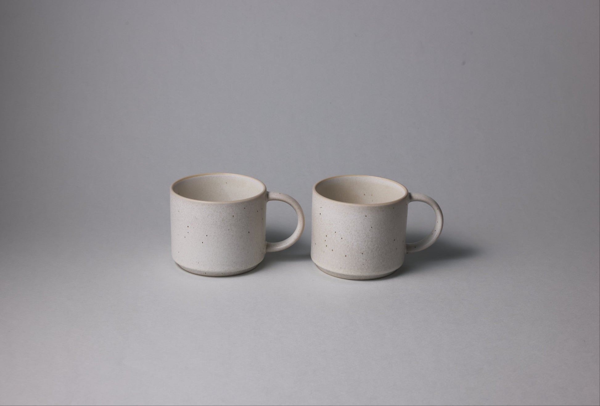 Two stoneware mugs with matte finish in soft beige