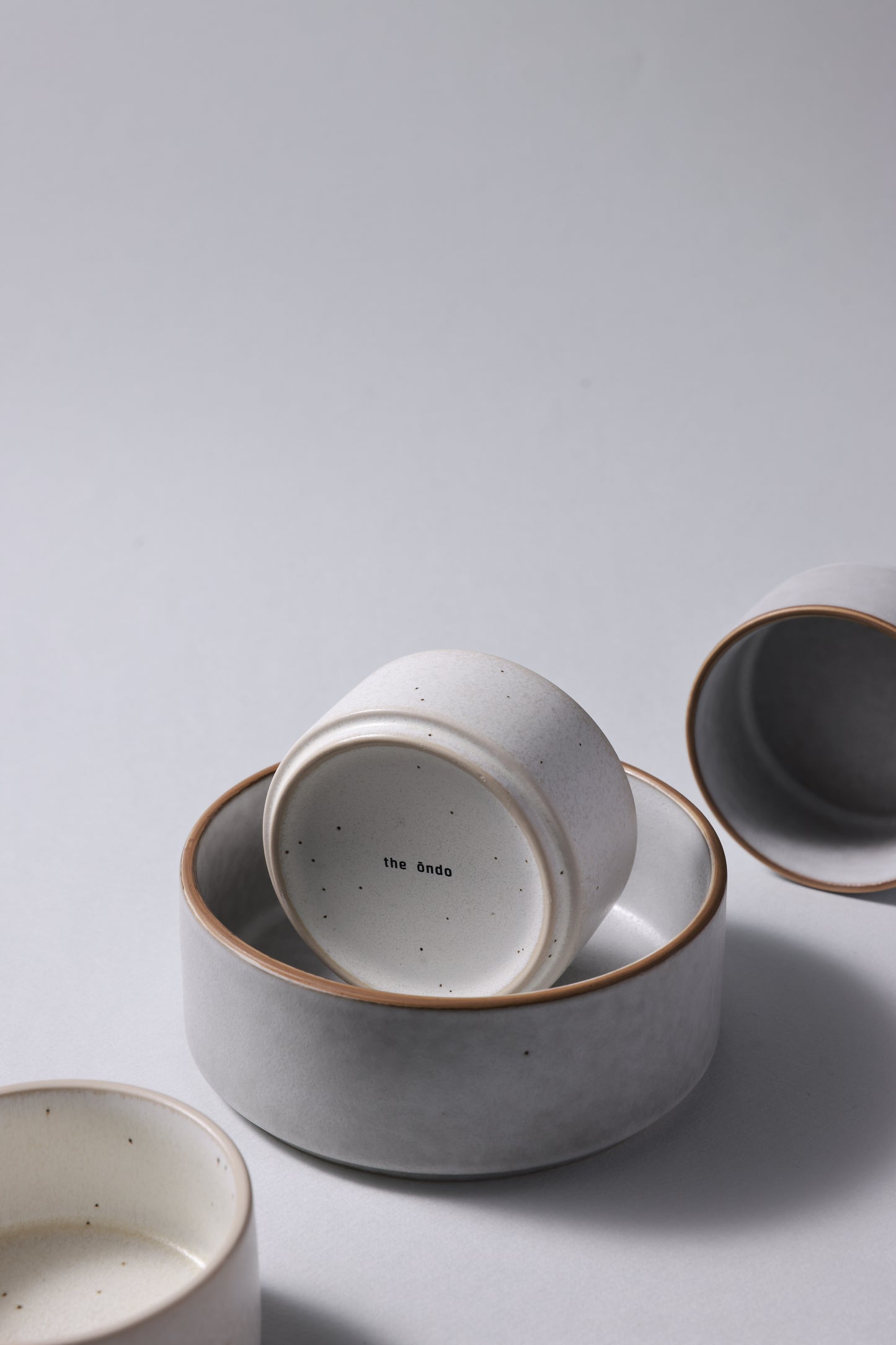 Two sizes of matte stoneware bowls arranged together, highlighting scale and quiet form