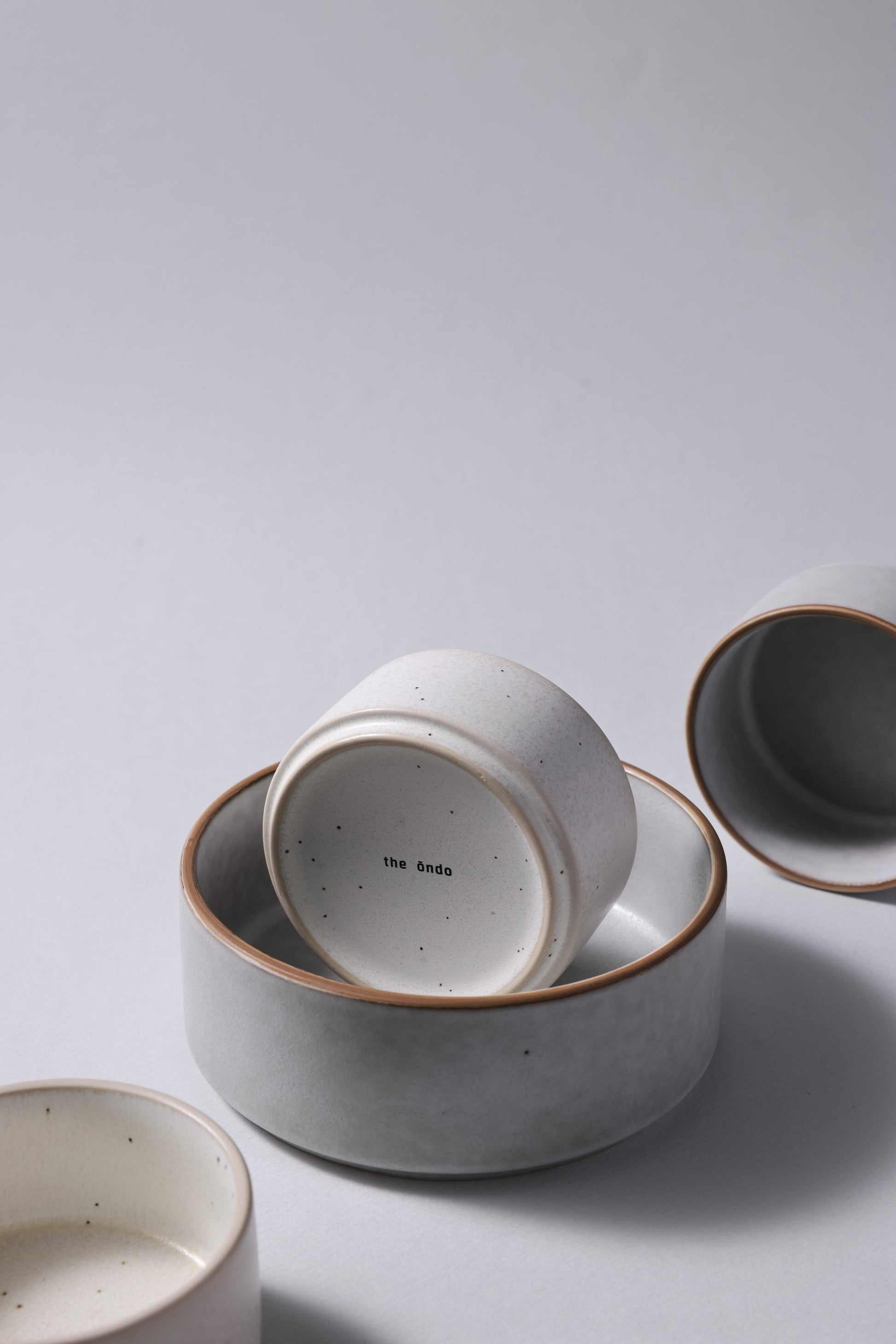Two sizes of matte stoneware bowls arranged together, highlighting scale and quiet form