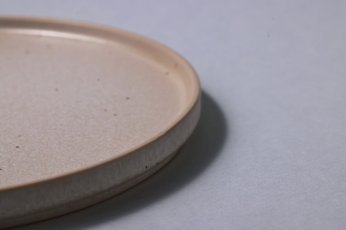 Medium stoneware plate with matte finish, soft gray, side profile